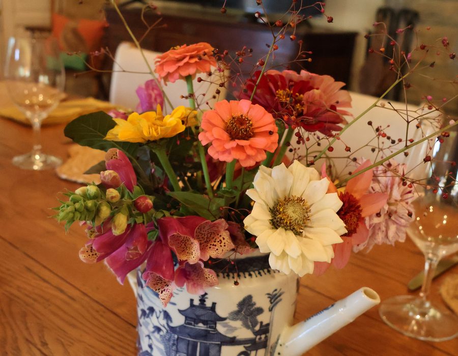Garden flowers in a blue jug on the table