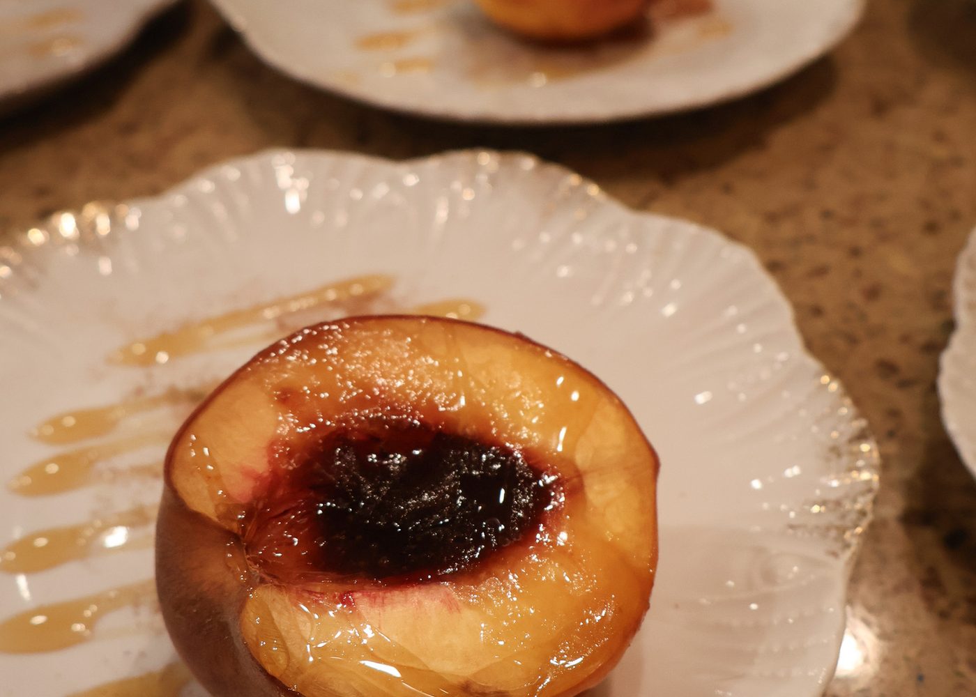 Roast peach with jam on a scalloped plate