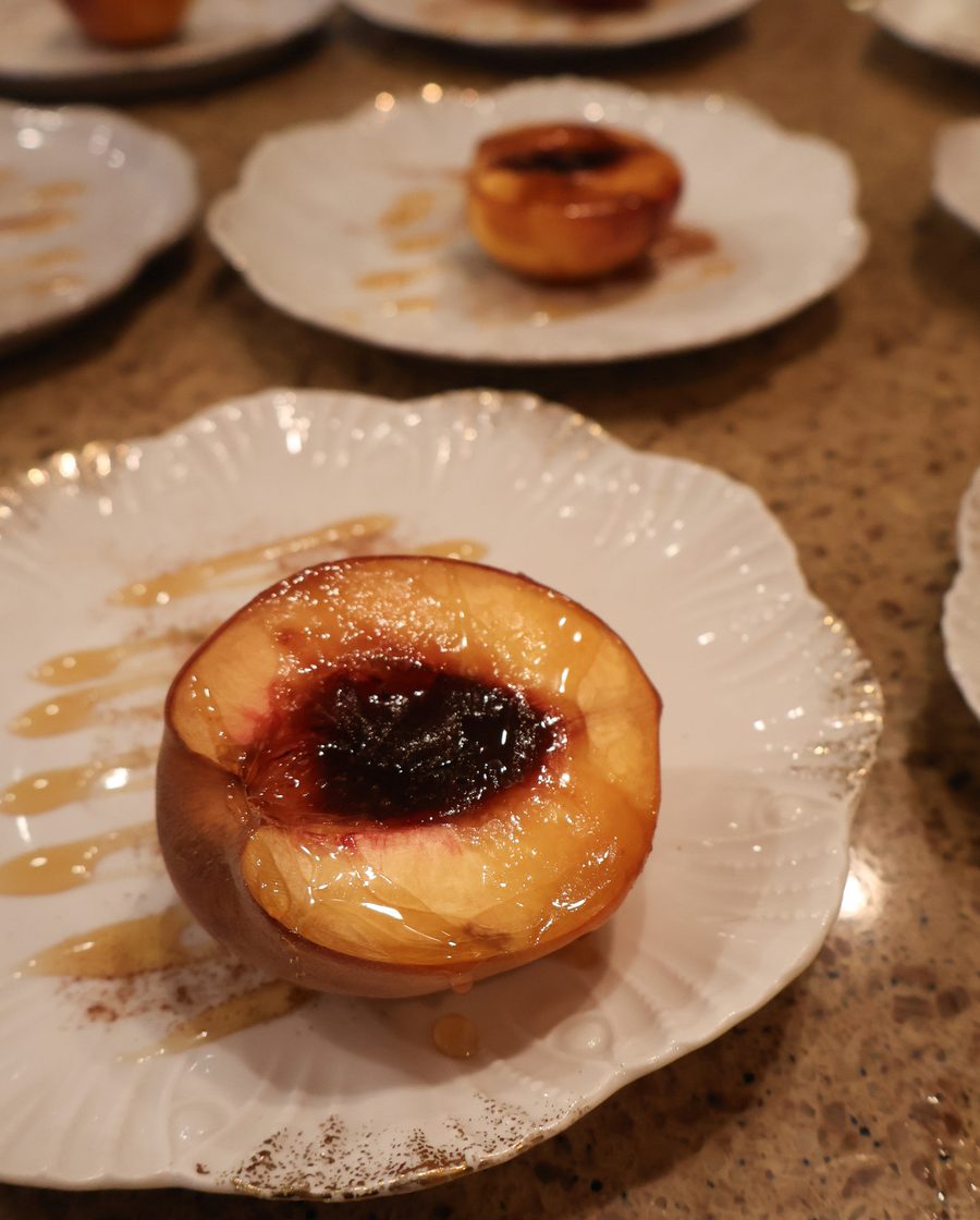 Roast peach with jam on a scalloped plate